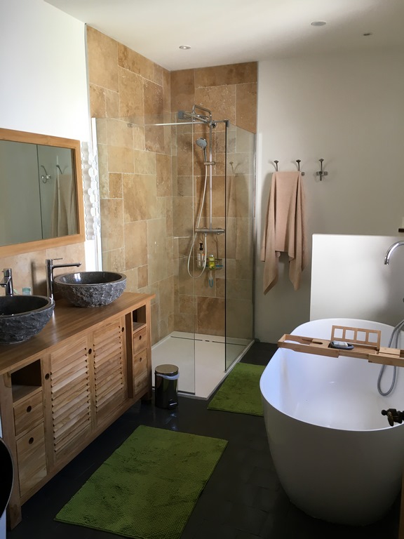 Salle de bains rénovée avec baignoire îlot et douche à Lozanne